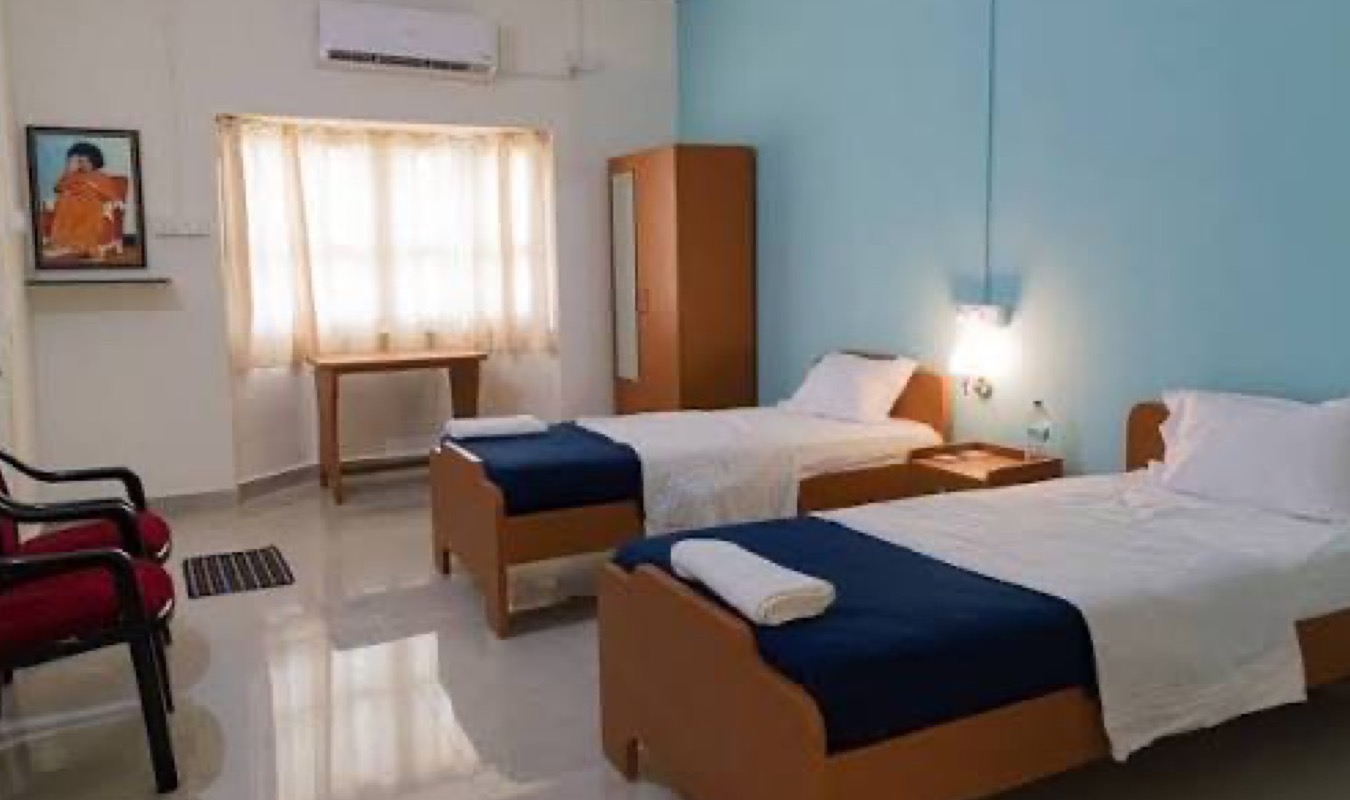 A renovated air-conditioned room with twin cots, wardrobe, writing desk and window light